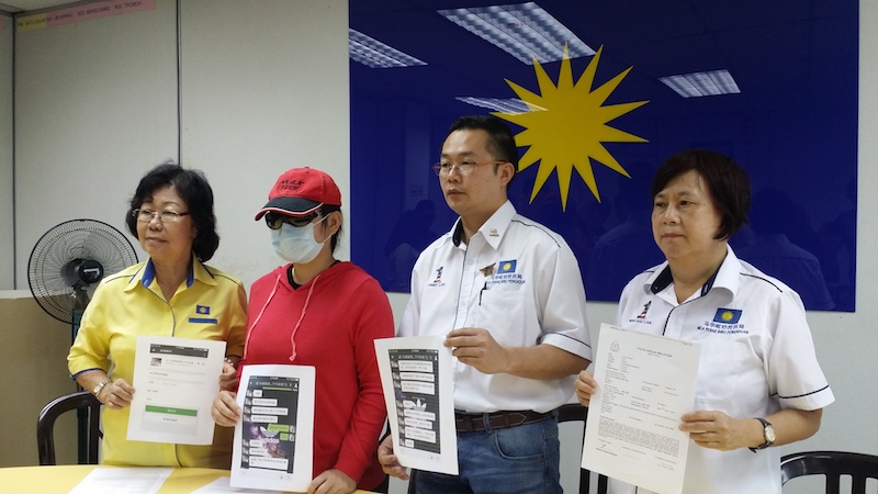 Perak MCA complaints bureau chief Jimmy Loh speaks to the blackmail victim to his right (in red) while holding screenshots of the WeChat conversation. u00e2u20acu201d Picture by Loghun Kumaran