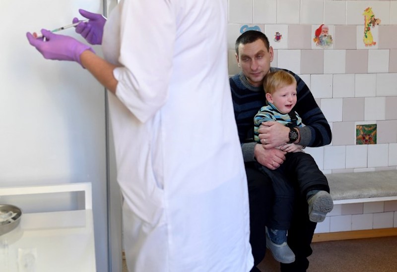 A nurse prepares a syringe for a vaccination against measles as a boy and his father wait in a paediatric polyclinic in Kiev January 15, 2018. u00e2u20acu201d AFP pic