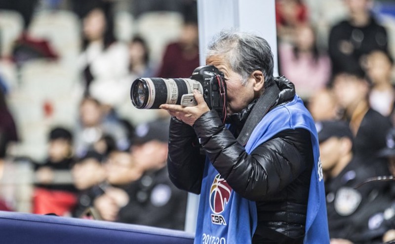 Photographer Hong Nanli, 79, takes pictures during a basketball match in Shanghai January 16, 2018. u00e2u20acu201d AFP pic