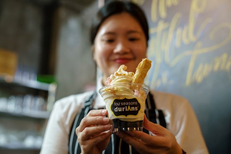 A staff member holds a cup of durian flavoured ice cream at Mao Shan Wang cafe in the Chinatown district of Singapore January 24, 2018. u00e2u20acu201d AFP pic