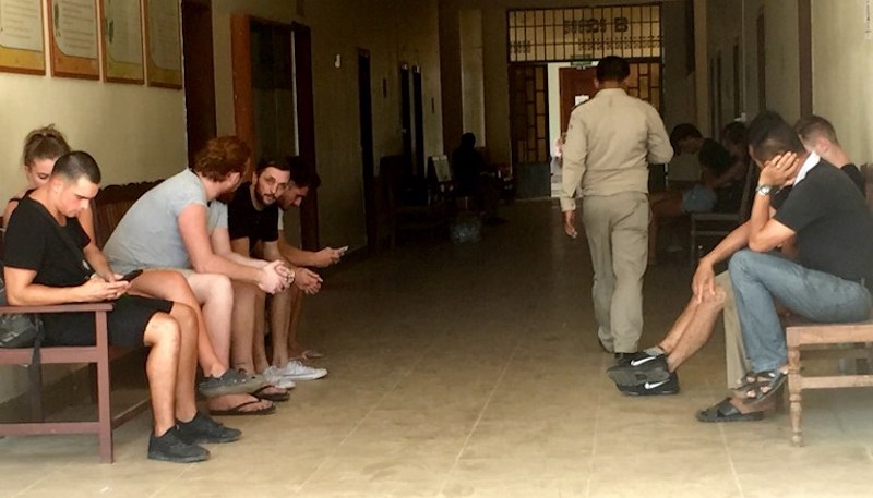 This photo taken on January 27, 2018 shows a group of foreigners outside a courtroom in Siem Reap province, some who were reportedly arrested on January 25 for allegedly 'singing and dancing pornographically'. u00e2u20acu201d AFP pic