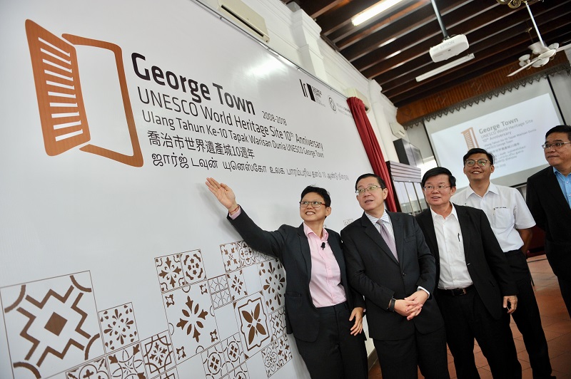 GTWHI general manager Ang Ming Chee (left) explaining the concept of the 10th anniversary logo after the launching by the Chief Minister Lim Guan Eng (second left) in George Town January 15, 2018. u00e2u20acu201d Picture by KE Ooi