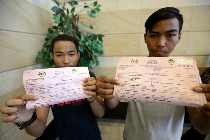Muhammad Rizal Abdullah (left) and Muhammad Fitri Abdullah (right) show their birth certificates which indicate they are u00e2u20acu02dcnon-citizensu00e2u20acu2122 during a press conference in George Town January 26, 2018. u00e2u20acu201d Picture by Sayuti Zainudin