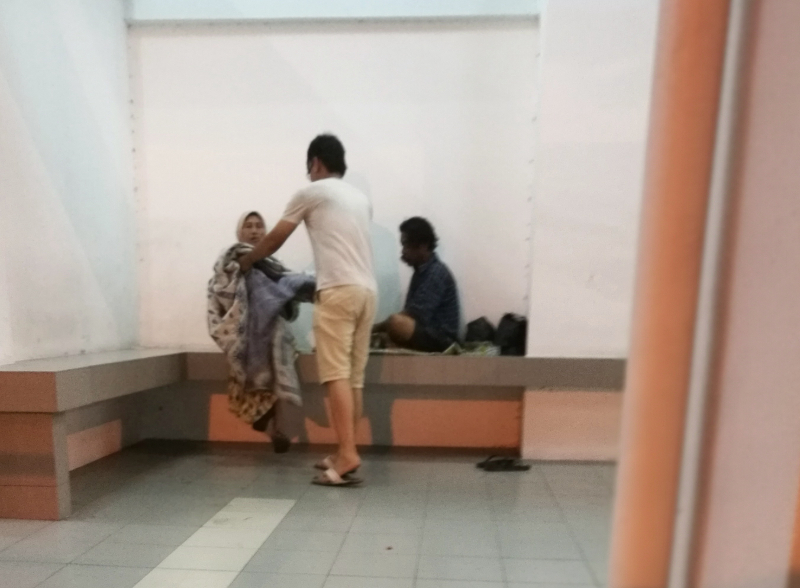 Issac Chin handing out pillows and blankets to a group of homeless people on the streets of Ipoh recently. u00e2u20acu201d Picture by Marcus Pheong