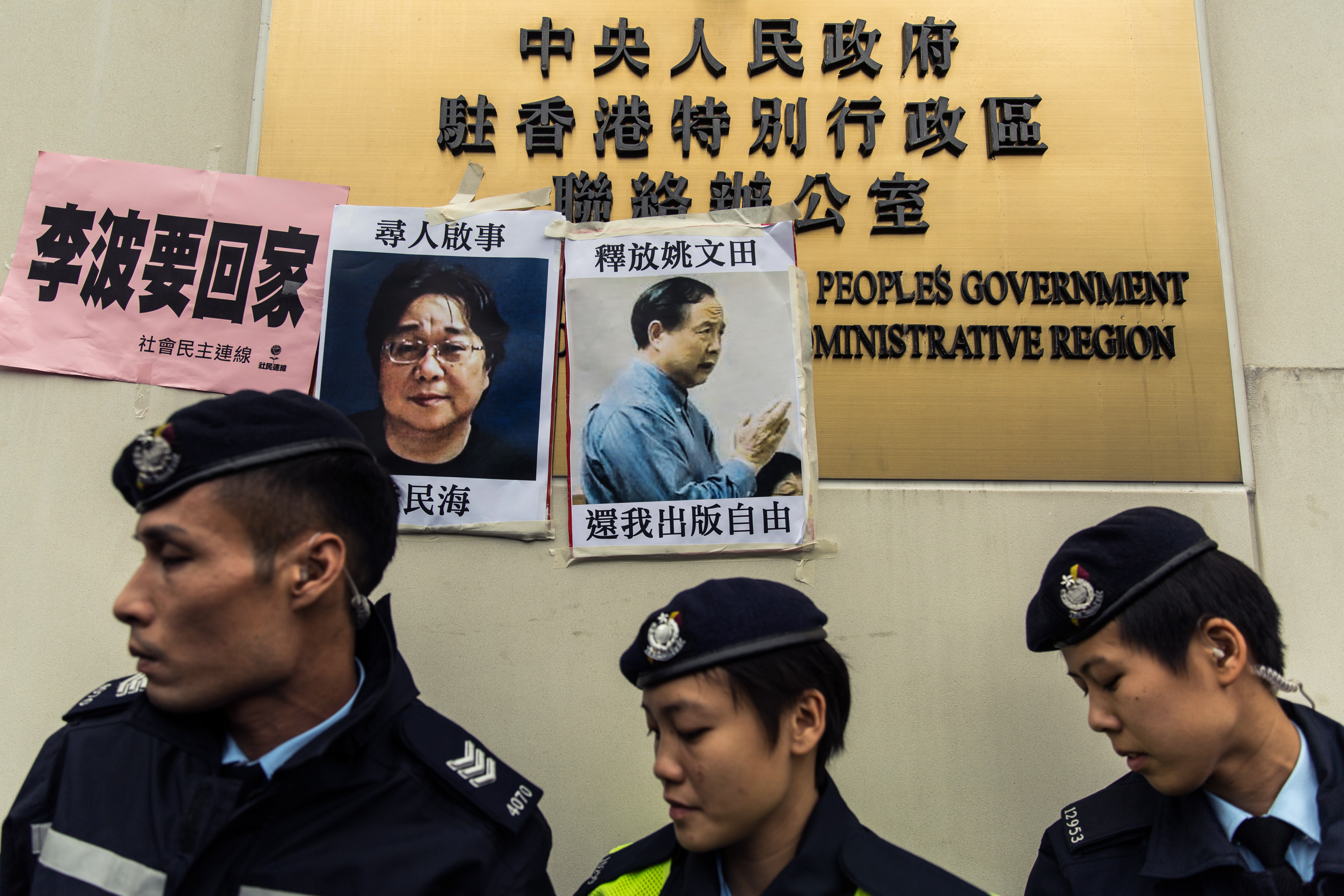 This file picture taken on January 3, 2016 shows police walking past missing person notices of Gui Minhai (left) and Yau Wentian. u00e2u20acu201d AFP pic 