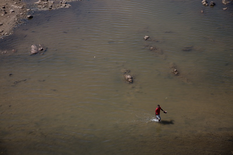 A man walks in the Mandrare River, in the Amboasary Sud area of southern Madagascar November 8, 2017. Many people travel daily to the river to collect water for their families. u00e2u20acu201d Thomson Reuters Foundation pic