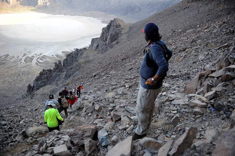 A Saudi guide leads a group of foreign tourists through the Al-Wahbah volcanic crater in the Al-Wahbah desert, some 360km northeast of Jeddah, November 17, 2017. — AFP pic