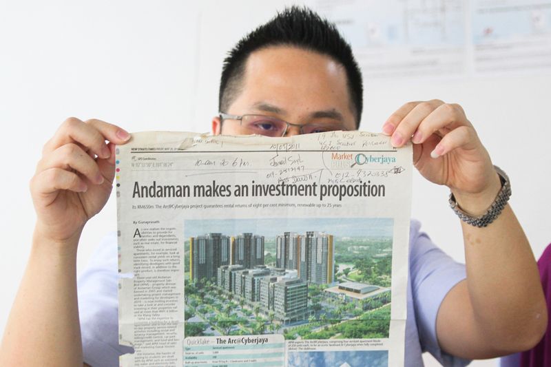 Condominium unit owner Lim Ta Wen holding up a newspaper cutting advertisement of The Arc’s guaranteed rental return scheme during a press conference in Cyberjaya, January 17, 2018. — Picture by Shafwan Zaidon