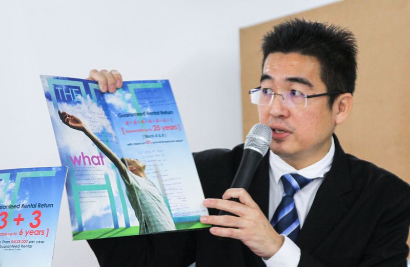 Lawyer Vincent Lim Chang showing the developeru00e2u20acu2122s brochure on the guaranteed rental return scheme of The Arc during a press conference in Cyberjaya, January 17, 2018. u00e2u20acu201d Picture by Shafwan Zaidon
