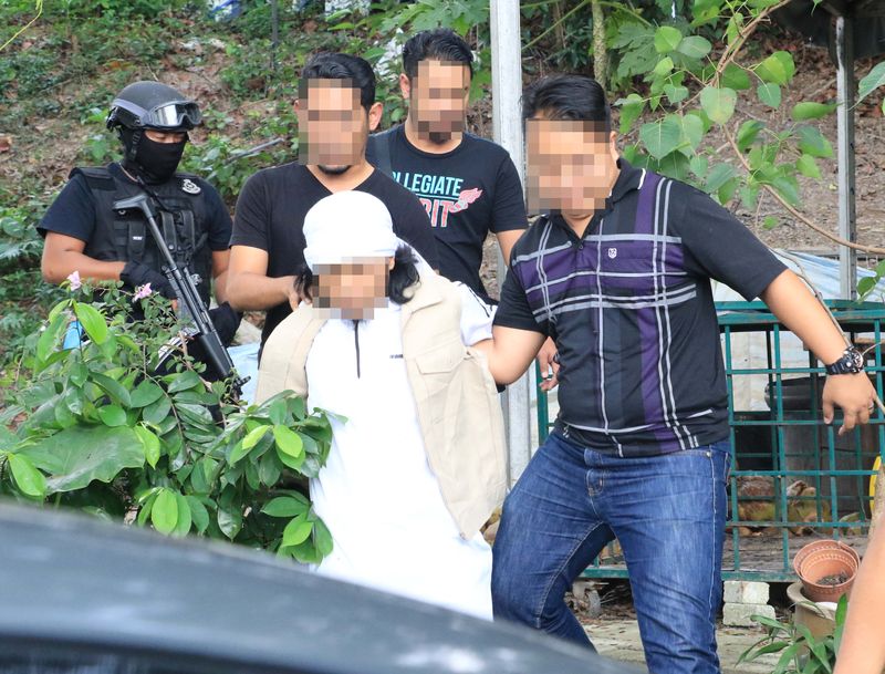 Police arresting a religious teacher suspected of involvement with IS, in Petaling Jaya. — Picture courtesy of Royal Malaysian Police