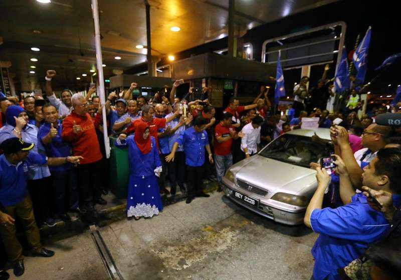 A group of Barisan Nasional supporters gather at the Sg. Rasau toll plaza in a show of support when the toll collection is abolished on January 1, 2018.