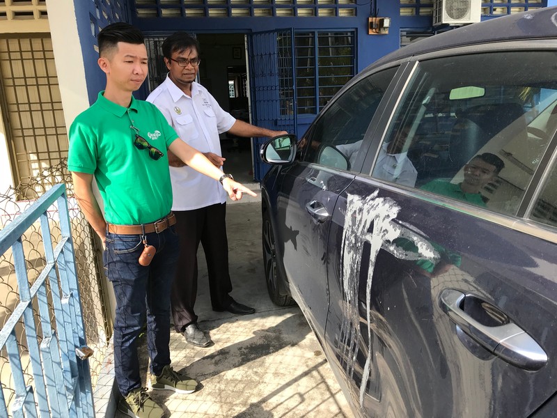 Jason Cheng, 34, (left) with Ipoh Barat Barisan Nasional Public Service and Complaints Centre chief Mohd Rawi Abdullah  showing the part of the car which were splashed with acid. u00e2u20acu201d Malay Mail pic
