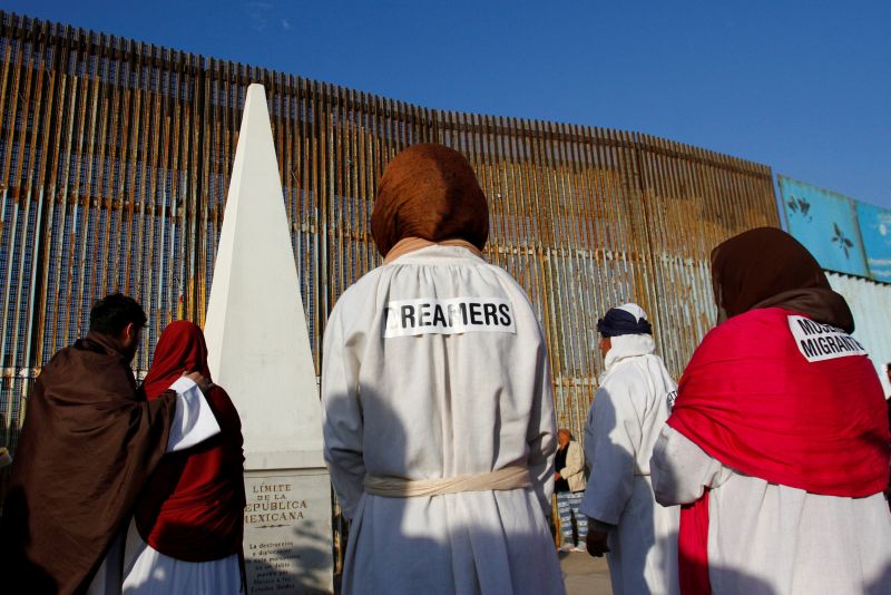 u00e2u20acu02dcDreamersu00e2u20acu2122, undocumented immigrants who arrived in the US when they were children, stand near the double steel fence that separates the US and Mexico at the border in Tijuana during the annual pre-Christmas u00e2u20acu02dcPosadau00e2u20acu2122 celebration organised by immigr