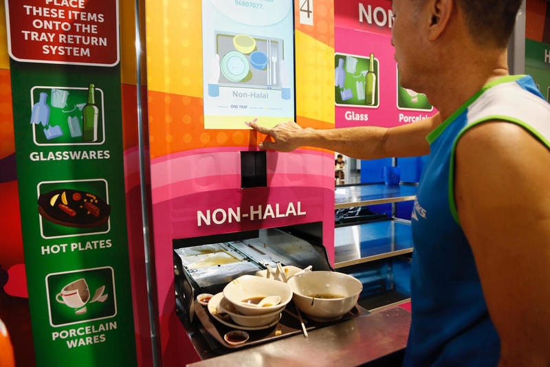 A customer at Marsiling Mall Hawker Centre returning his tray. A 50 Singapore cents deposit will be refunded when a tray is returned. u00e2u20acu201d TODAY picn