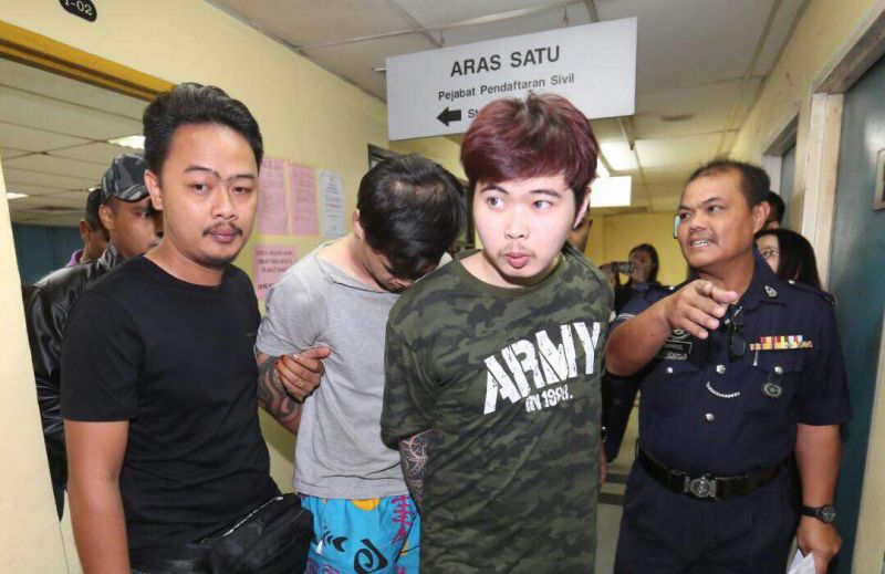 Yip Kah Hou (in front) and Gan Jia Ji are escorted by police after the charges were read to them at the Johor Baru Magistrateu00e2u20acu2122s Court today, January 11, 2018. u00e2u20acu2022 Picture by Ben Tan