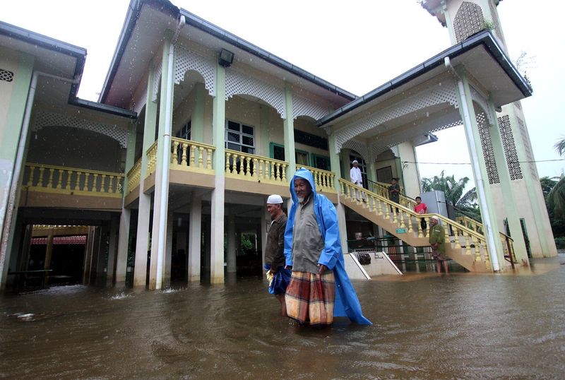 Jemaah masjid meredah air bah yang memasuki perkarangan Masjid Al Ehsan Kampung Pulau Rusa selepas mereka menunaikan solat Jumaat di Pekan, 12 Januari, 2018. u00e2u20acu201d Foto Bernama