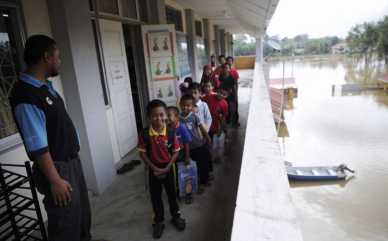 Pupils at SK Temai in Pekan appear cheerful after wading through floodwaters to attend class, January 16, 2018. u00e2u20acu201d Bernama