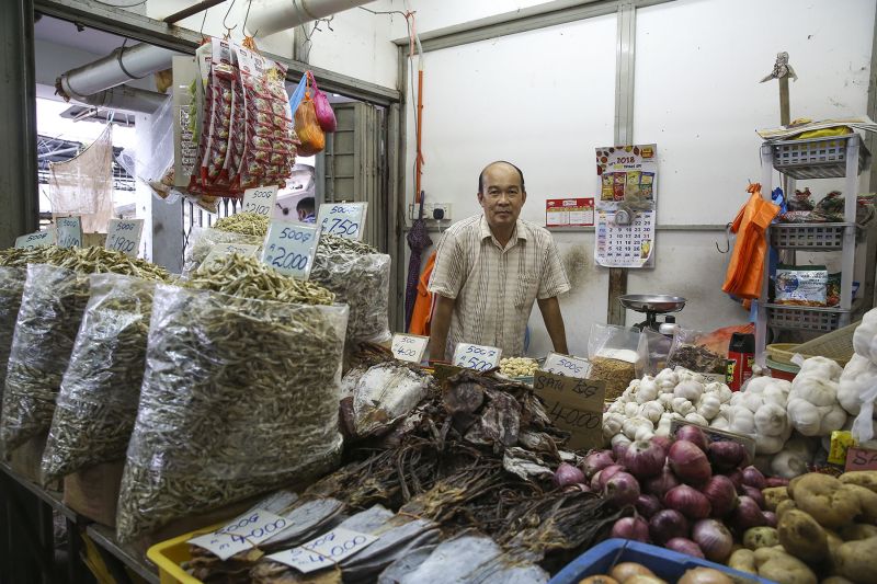 Dry seafood trader, Wong Poh Wah, stands in his shop at a market in Kuala Lumpur.