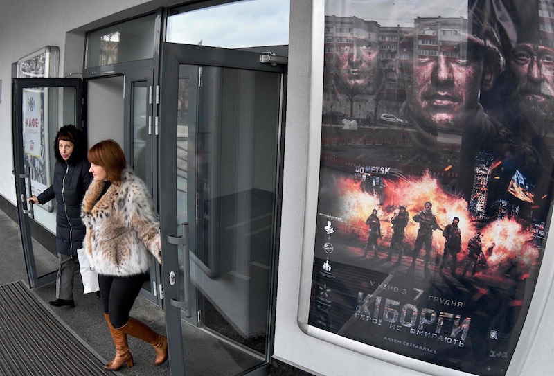 People leave from a cinema featuring a poster for the Ukrainian blockbuster film u00e2u20acu02dcCyborgsu00e2u20acu2122 in Kiev on December 16, 2017. u00e2u20acu201d AFP pic