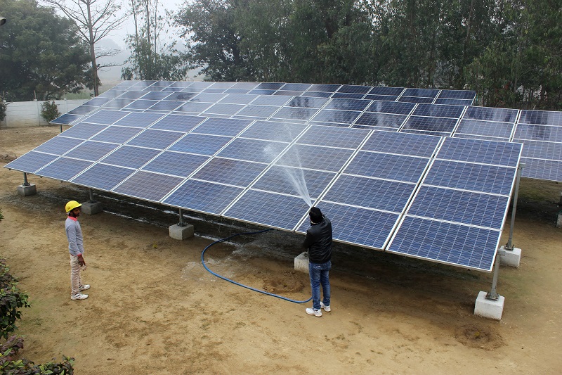 Solar panels are washed at a solar mini-grid installation in Kamlapur, in the Indian state of Uttar Pradesh, January 9, 2018. 