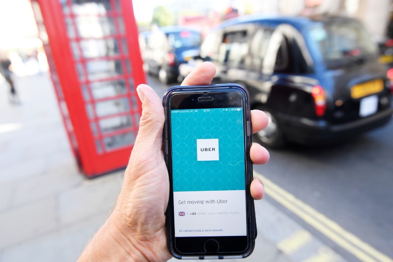 A photo illustration shows a London taxi passing as the Uber app logo is displayed on a mobile telephone, as it is held up for a posed photograph in central London September 22, 2017. u00e2u20acu201d Reuters pic