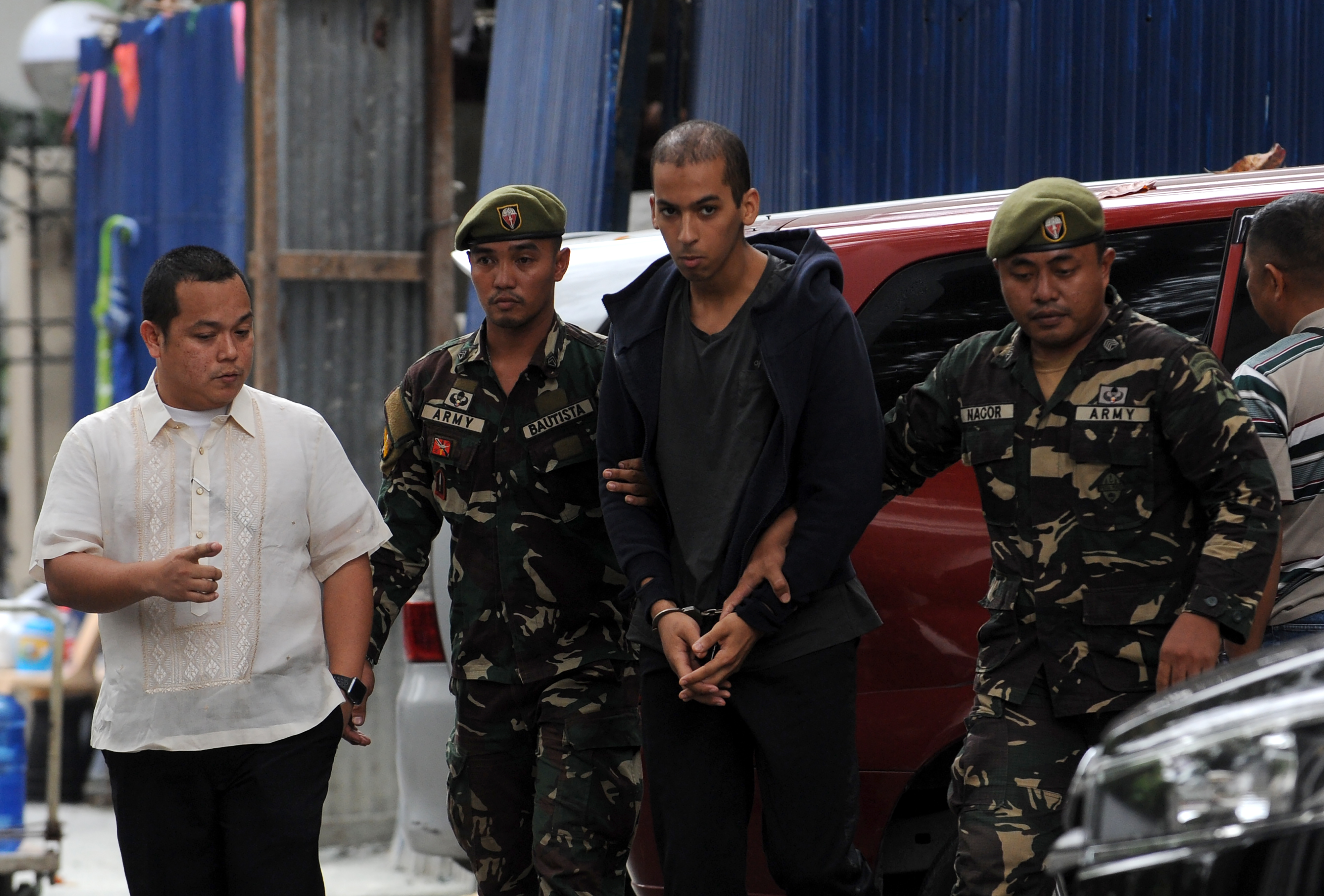 Abdelhakim Labidi Adib (centre) is escorted by Philippine soldiers as he arrives at the Department of Justice building in Manila on January 24, 2018. u00e2u20acu201d AFP pic
