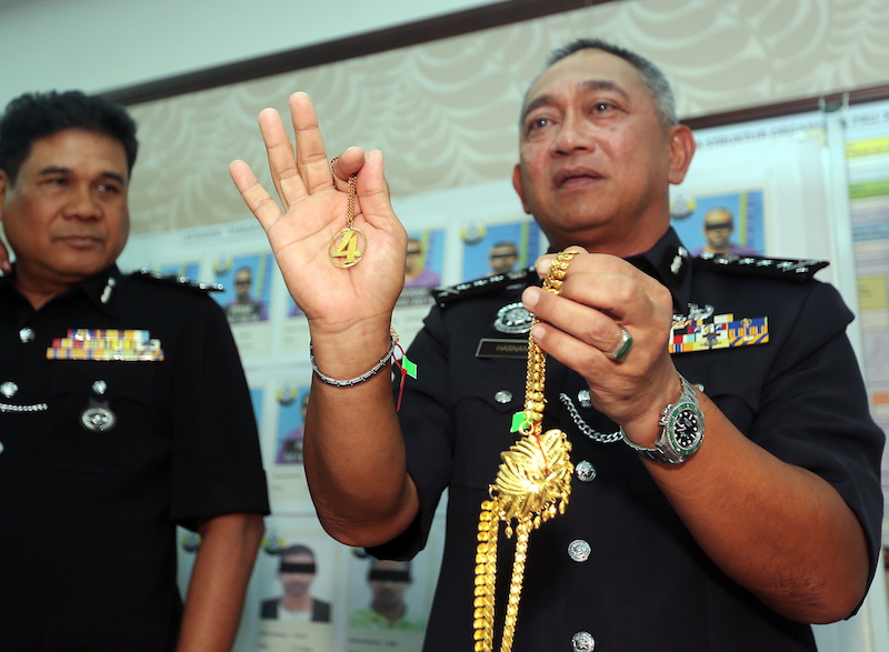 Perak Police Chief Datuk Hasnan Hassan shows jewellery decorated with the 04 Gang symbol that was seized in Ops Cantas Silver 1. u00e2u20acu201d Picture by Farhan Najib
