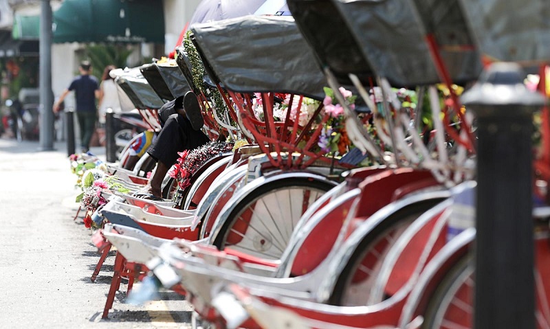 A trishaw paddler rests under the shade of his trishaw at Lebuh Penang in George Town February 19, 2018. u00e2u20acu201d Picture by Sayuti Zainudin