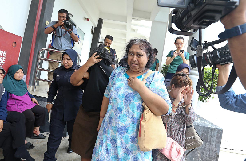 MA Ambika (in light blue) and her daughter R. Jayavartiny (in black) being escorted by the police at the Bukit Mertajam Magistrate Court February 21, 2018. u00e2u20acu201d Picture by Sayuti Zainudin