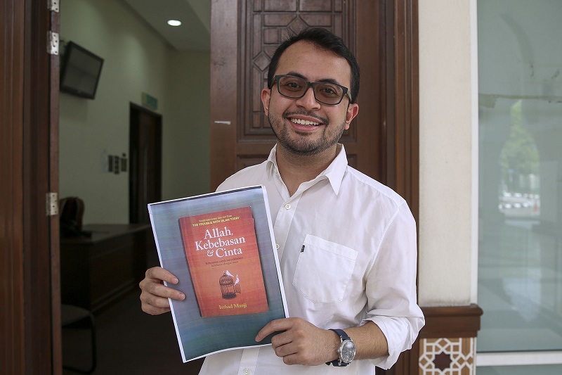 Mohd Ezra Mohd Zaid holds a picture of the Bahasa Malaysia translation of Irshad Manjiu00e2u20acu2122s book u00e2u20acu02dcAllah, Love and Libertyu00e2u20acu2122 outside the courtroom at the Shariah Subordinate Court in Petaling Jaya on February 22, 2018. u00e2u20acu201d Picture by Yusof Mat Isa