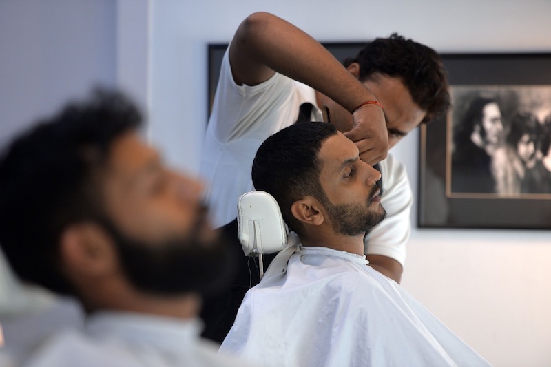 This photograph taken on October 10, 2017 shows a male hairdresser cutting the hair of a customer at a men's salon in Islamabad. u00e2u20acu201d AFP pic