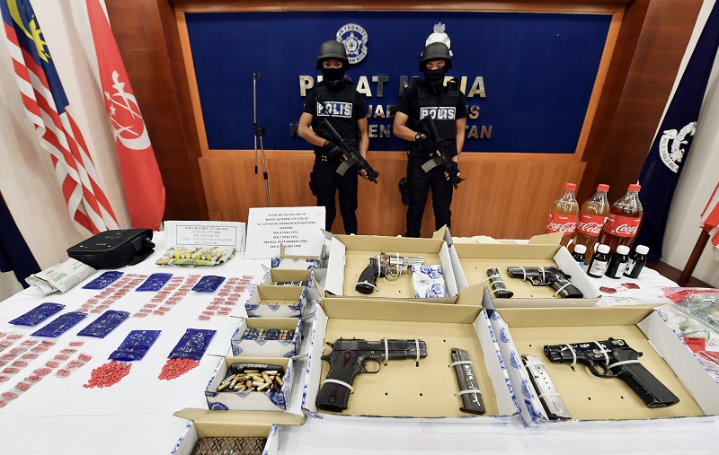 Some of the guns and drugs seized by the police during the raids in Ketereh. u00e2u20acu201d Bernama pic