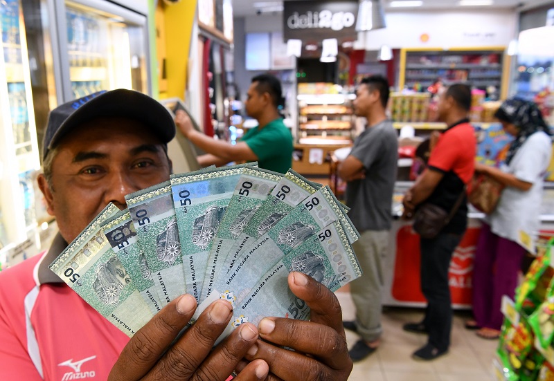 A 1Malaysia Peopleu00e2u20acu2122s Aid (BR1M) recipient reacts after receiving the aid via his bank account in Kuantan February 28, 2018. u00e2u20acu201d Bernama pic