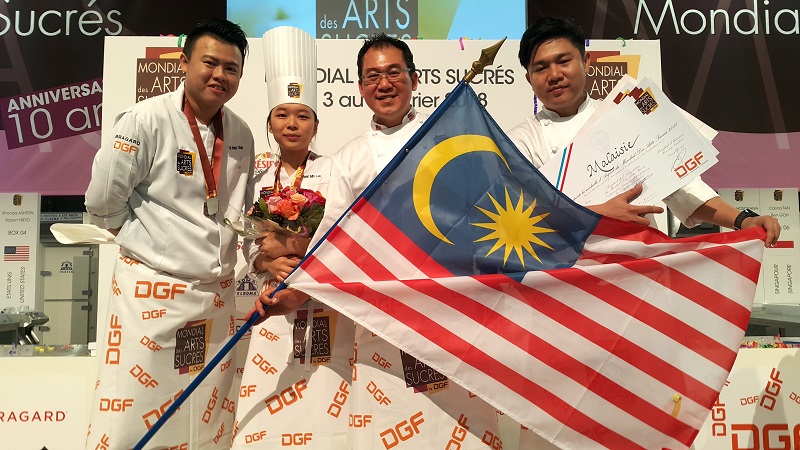 Chef Yap Kean Chuan (left) from the Academy of Pastry Arts Malaysia and chef Lau Hwei Min from Harold's Academy with the silver medal they won at the Mondial des Arts Sucres (International Confectionary Arts Competition) in France recently. u00e2u20acu2022 Picture co