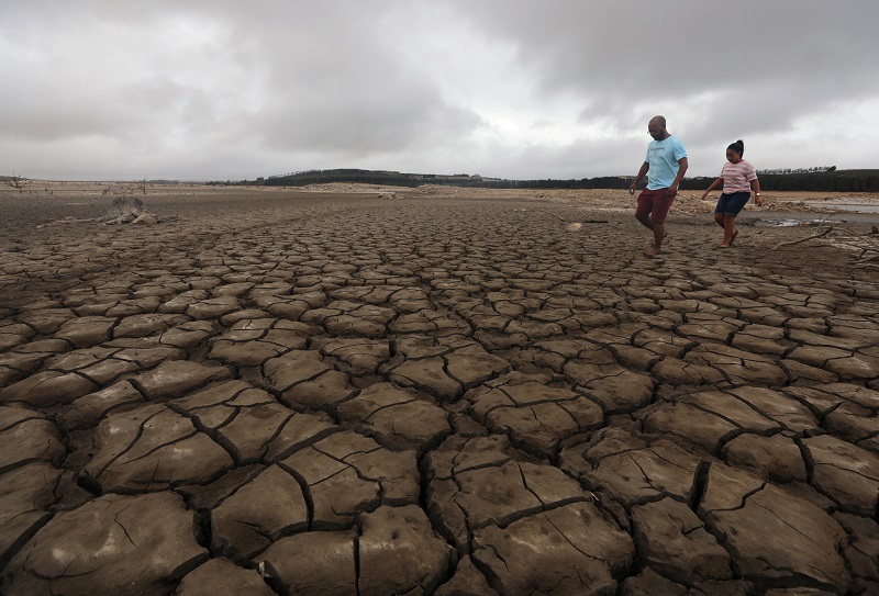 A family negotiates their way through caked mud around a dried up section of the Theewaterskloof dam near Cape Town, South Africa, January 20, 2018. u00e2u20acu2022 Reuters pic
