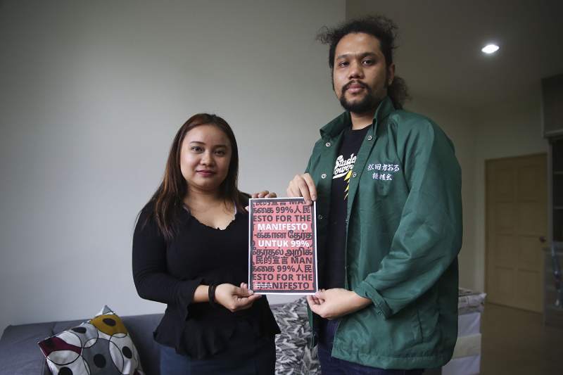 Gabungan Kiri committee members Maryam Lee (left) and Zikir Rahman holds up the Manifesto 99% book after an interview with Malay Mail in Petaling Jaya February 4, 2018. u00e2u20acu201d Picture by Yusof Mat Isa