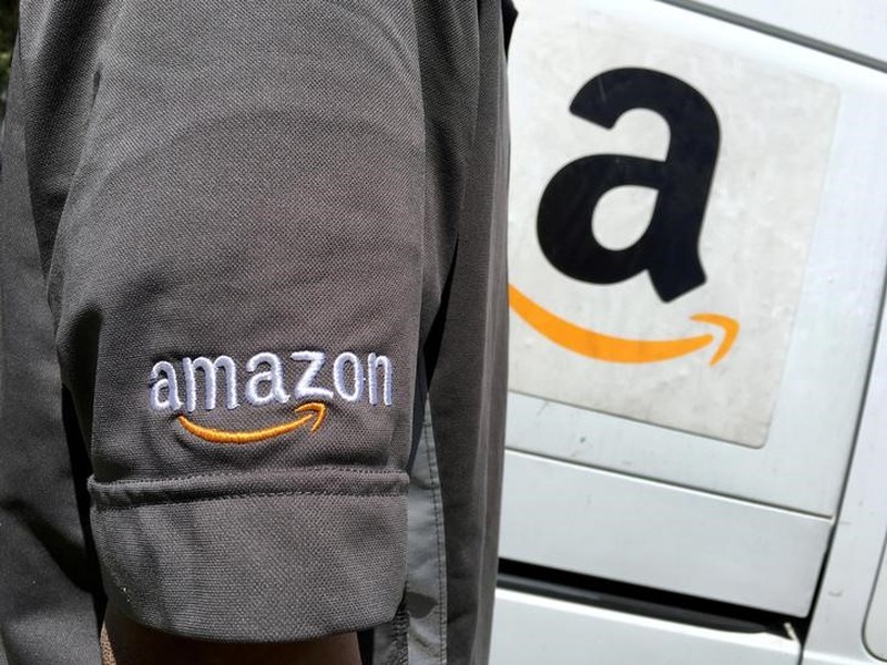 An Amazon.com Inc driver stands next to an Amazon delivery truck in Los Angeles May 21, 2016. u00e2u20acu201d Reuters pic n