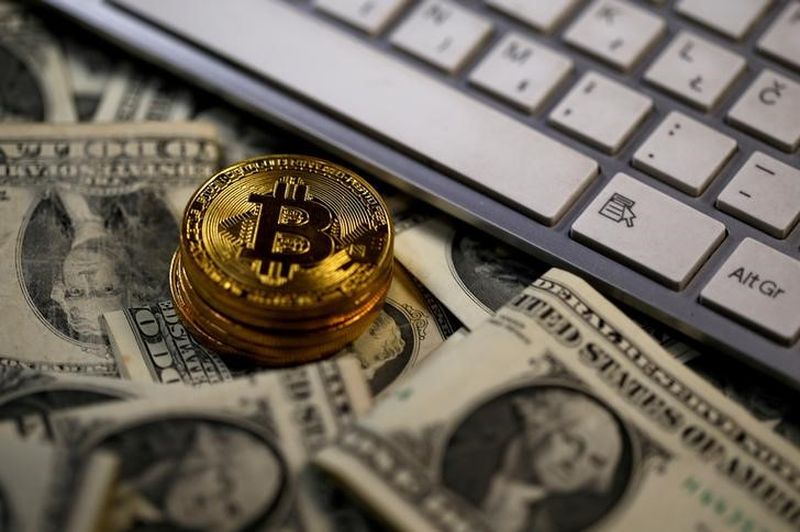 Bitcoin (virtual currency) coins placed on dollar banknotes, next to computer keyboard, are seen in this illustration picture, November 6, 2017. u00e2u20acu201d Reuters pic