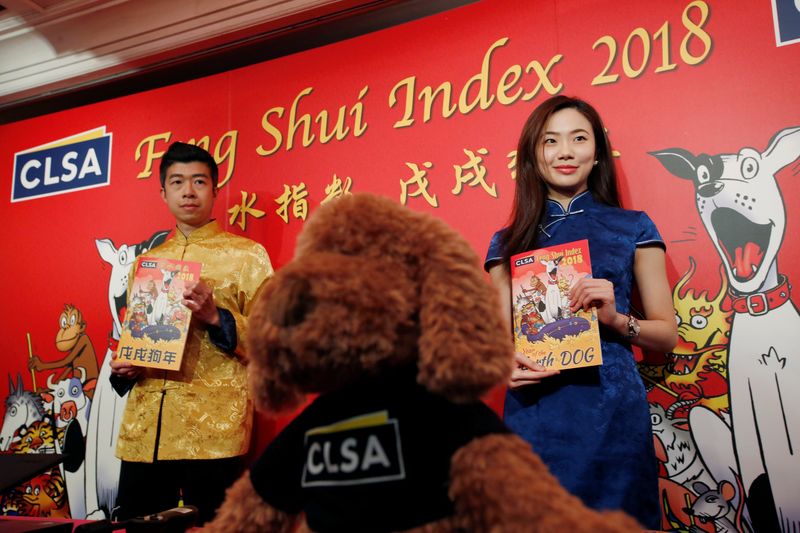 u00e2u20acu02dcSorcereru00e2u20acu2122s apprenticeu00e2u20acu2122Sally Chan and u00e2u20acu02dcwand beareru00e2u20acu2122 Alec So from CLSA pose with the Feng Shui Index report for Chinese Year of the Dog, in Hong Kong, China, February 5, 2018. u00e2u20acu201d Reuters pic