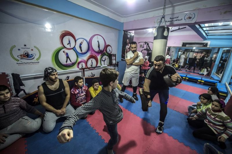 Syrian refugee Amir al-Awad (right) watches as Adel Bazmawi (left) teaches martial arts to a youth at the academy in Egypt's second city of Alexandria. u00e2u20acu2022 AFP pic