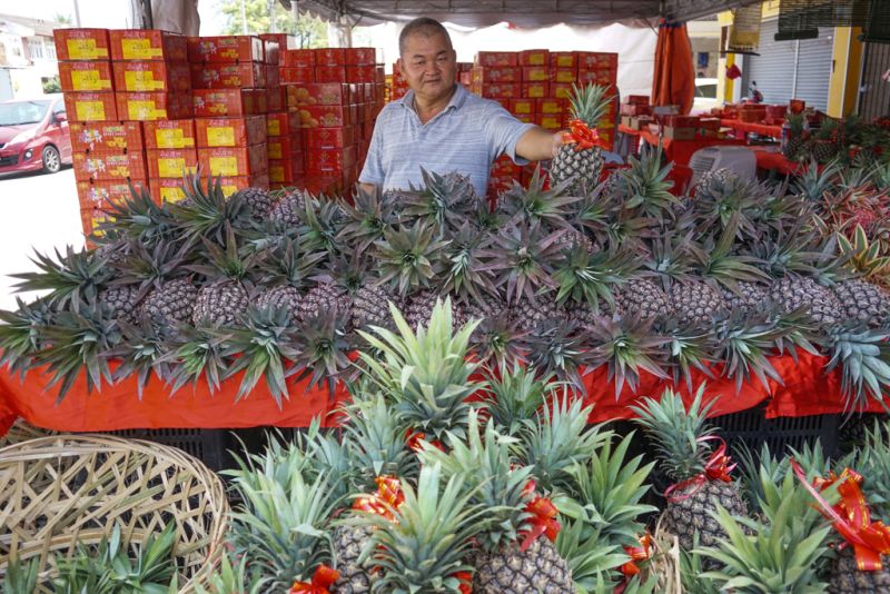 A fruit vendor sells pineapples for the upcoming Chinese New Year celebrations in Ipoh February 10, 2018. u00e2u20acu2022 Picture by Ahmad Zamzahuri
