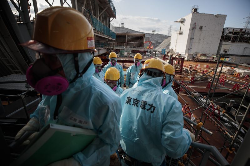 File picture shows employees of Tokyo Electric Power Company (TEPCO) standing in front of the companyu00e2u20acu2122s reactor number 3 at Fukushima Dai-ichi nuclear power plant in Okuma, Fukushima prefecture, January 31, 2018. u00e2u20acu201d AFP pic