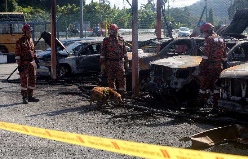 Forensic personnel from the Fire Dept are pictured inspecting vehicles that were burnt in a suspected arson attack at the Kuala Kangsar Road Transport Dept office February 6, 2018. u00e2u20acu201d Picture by Farhan Najib