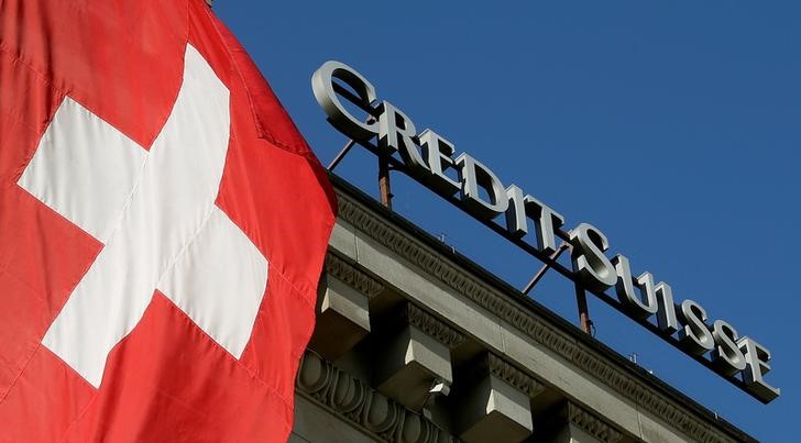 Switzerland's national flag flies next to the logo of Swiss bank Credit Suisse at a branch office in Luzern, Switzerland October 19, 2017. u00e2u20acu201d Reuters picn