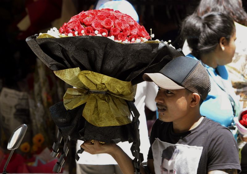 A man is pictured with a huge bouquet of roses in Kuala Lumpur ahead of Valentine's Day on February 13, 2018. u00e2u20acu201d Picture by Ham Abu Bakar