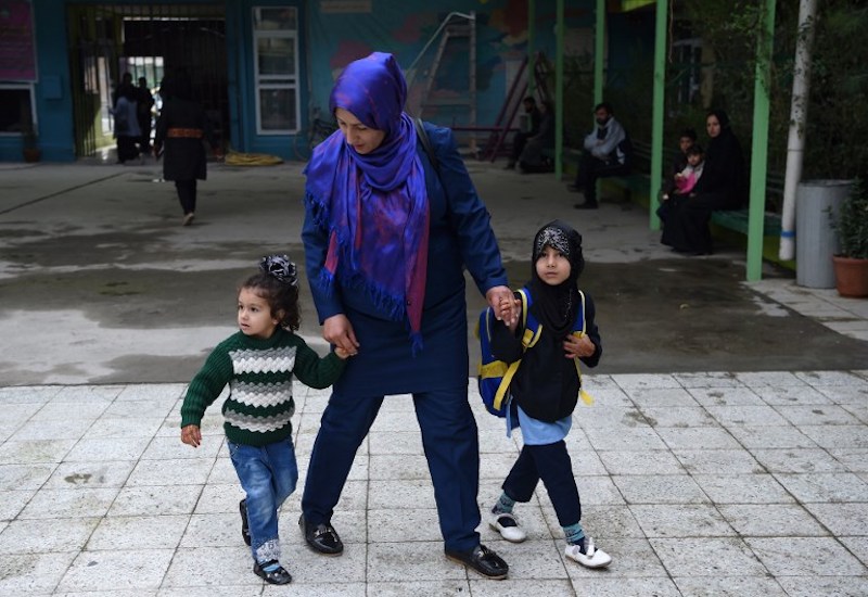 Afghan mother Maliha arrives with her daughters Sana (right), five, and Sama, three, on their first day of the school year at a private school in Kabul March 24, 2018. u00e2u20acu201d AFP pic