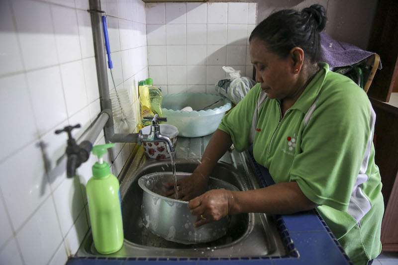 Wan Zainab Hori washes a pot in her kitchen at Pangsapuri Blok 14, Keramat AU3 in Hulu Klang March 10, 2018. Water supply to the area is back to normal after days of water disruption. u00e2u20acu201d Picture by Yusof Mat Isa