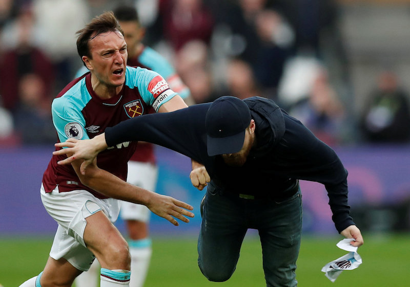 West Ham Unitedu00e2u20acu2122s Mark Noble clashes with a fan who invaded the pitch during their match against Burnley in London March 10, 2018. u00e2u20acu201d Action Images pic via Reuters
