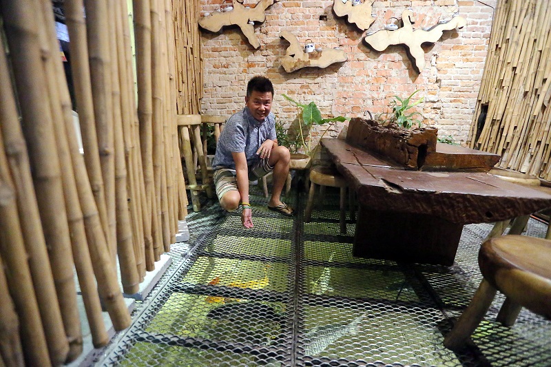 Happy 8 hotel managing director Tan Kai Lek feeds carps at a specially designed fish feeding space in his hotel. — Picture by Farhan Najib 