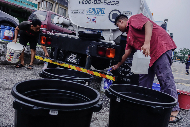 Residents from Taman Bukit Kuchai in Puchong fill up container with water due to water disruption in Klang valley March 7, 2018. u00e2u20acu201d Picture by Shafwan Zaidon